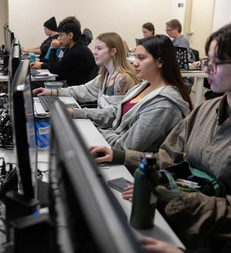Students in a row on computers in the Concept Forge working on 3D software for printing