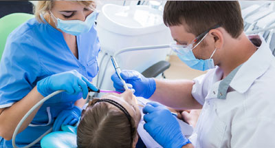 Photo of a dental assistant helping a dentist work on a patient