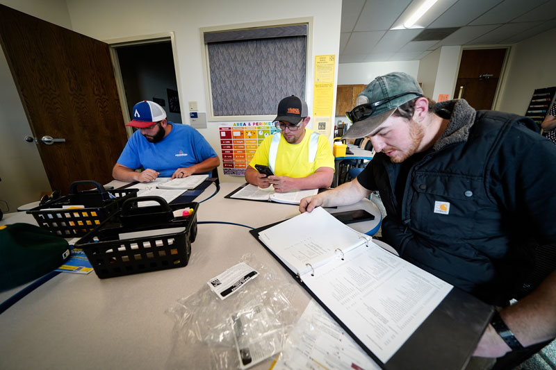 photo of apprentice students studying materials at a table