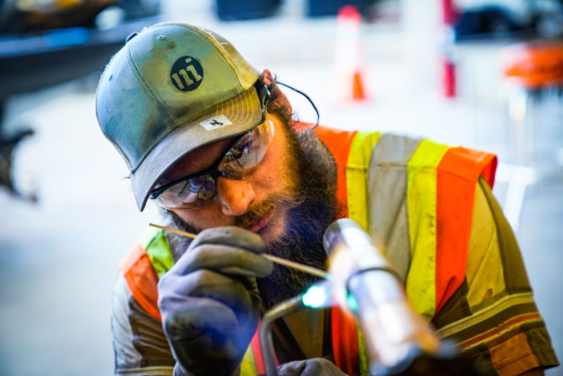 photo of student welding a pipe