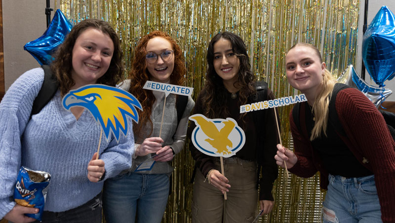 Photo of four students posing with LCCC and Davis Scholar signs