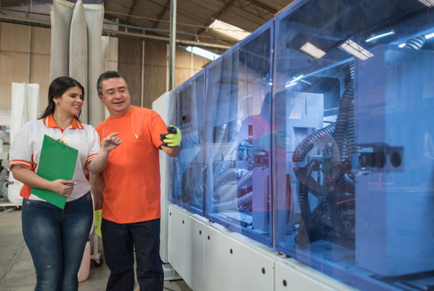 man and woman looking at manufacturing machine